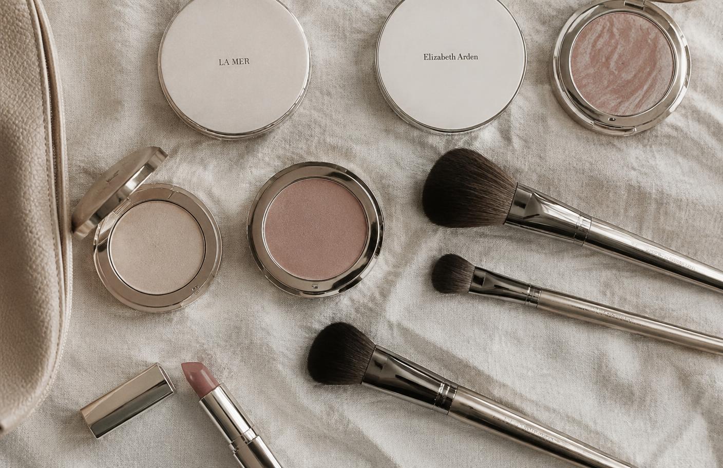 Makeup brushes and compacts arranged on linen